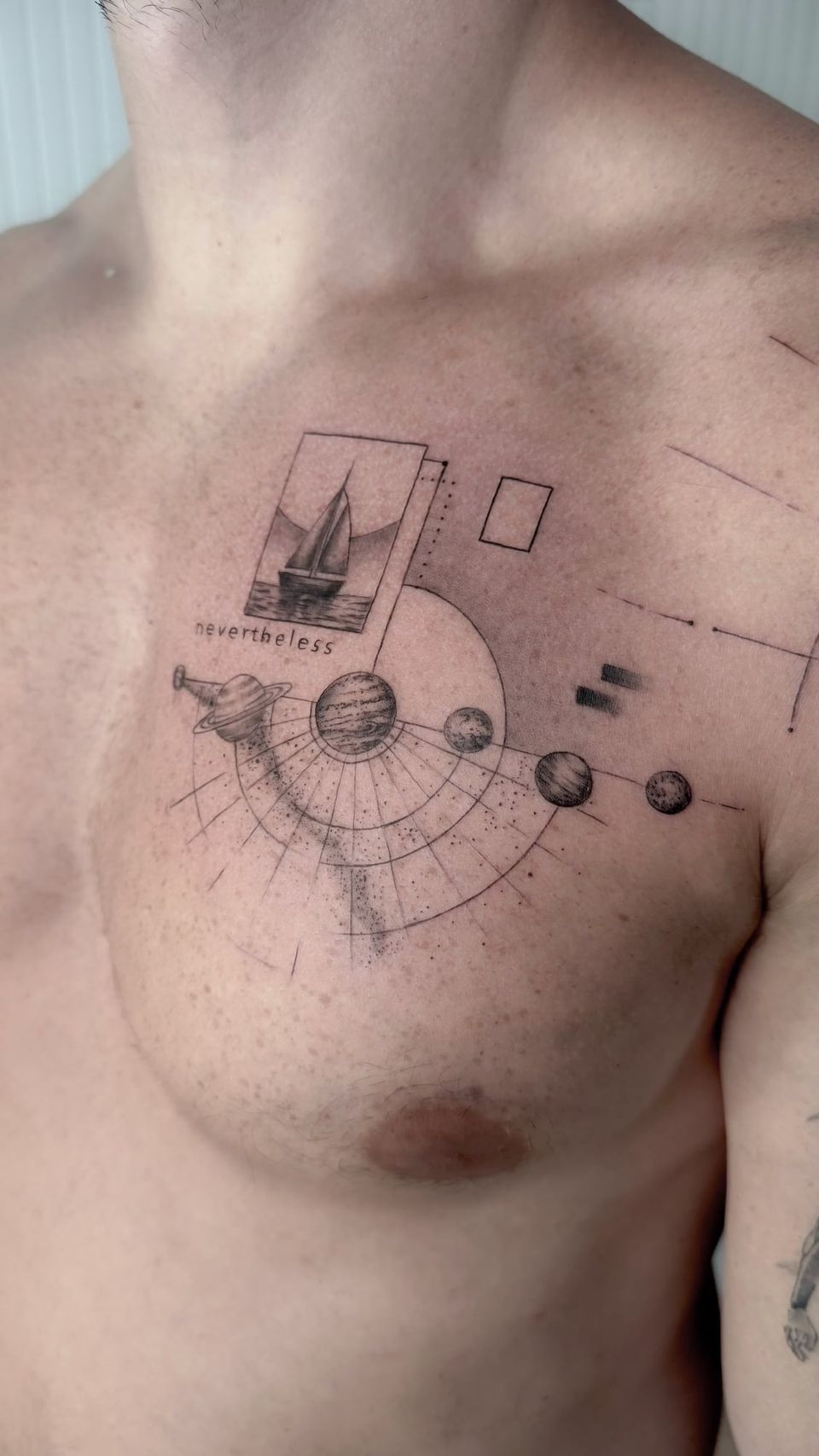Tatuaje conceptual en el pecho: velero dentro de un marco con la palabra «nevertheless» y los planetas del sistema solar en órbita, con líneas y formas geométricas